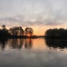 The sun is setting over a lake, creating a beautiful reflection on the water.