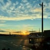 A sunset over an airport with planes sitting on the tarmac.