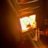 A person is pulling out a match from a fire place that is already lit.