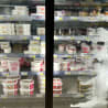 A lot of yogurt is sold in a store with a lot of ice cream on display as well.
