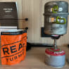 A small gas stove with a bag of real Turmat on the counter.