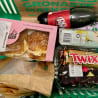 A basket of food and a bottle of Dr. Pepper.