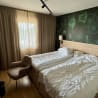 A hotel room with a bed and a chair in it.