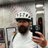 A man wearing a helmet takes a picture of himself in the mirror.
