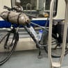 A bike with a water bottle on it and a metal pole next to it on a subway train.