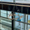 A large horned chandelier hangs in a glass building.