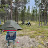 A chair and a bike are set up in a campsite.