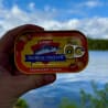 A hand holding a can of fish with the word "stabburmack" on it.