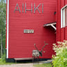 A reindeer standing in front of a building with a sign that reads Aiihki.