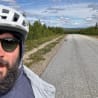 A man wearing a helmet is taking a picture of himself in the mirror.