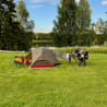 A tent is set up on a grassy area with a bicycle nearby.