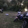 A man is standing next to a motorcycle in a field.