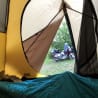 A tent with a bike in it and a person sleeping inside of it.