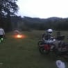 People are camping in the outdoors and have their bikes parked nearby.