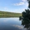 A lake is reflected in a tree branch and the sky.