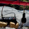 A remote control sits on a snowy log with a microphone attached to it.