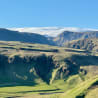 A mountain with a large slab of snow on top of it.