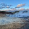 A large open pit with steam coming out of it.