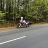 A person is taking a picture of a motorcycle on the side of the road.