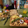 A table with two plates of food and two bottles of drinks.