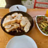 A table with three plates of food including some kind of bread.