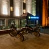 Two motorcycles are parked in front of a building at night.