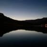 A lake at sunset with trees in the background.