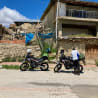 A man is standing next to his motorcycle on the street.