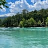 A river with trees and a blue sky in the background.