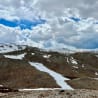 A mountain with a lot of snow on it and a path going through it.