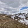 A road winds its way up a mountain covered in snow.