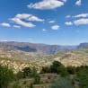 A mountain view with clouds and a blue sky in the background.
