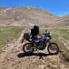 A man is sitting on his motorcycle in the middle of a field.
