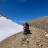 A man on a dirt bike on the side of a mountain.