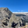 A mountain with a rocky terrain and a tree covered by a cloud.