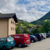 Several cars are parked, including a red Miele van.