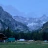 A group of campers are parked in front of a large mountain range.