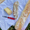 A knife and some bread are on a piece of paper.
