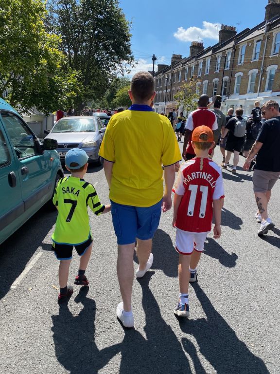My sons and I walking along a road in Arsenal shirts