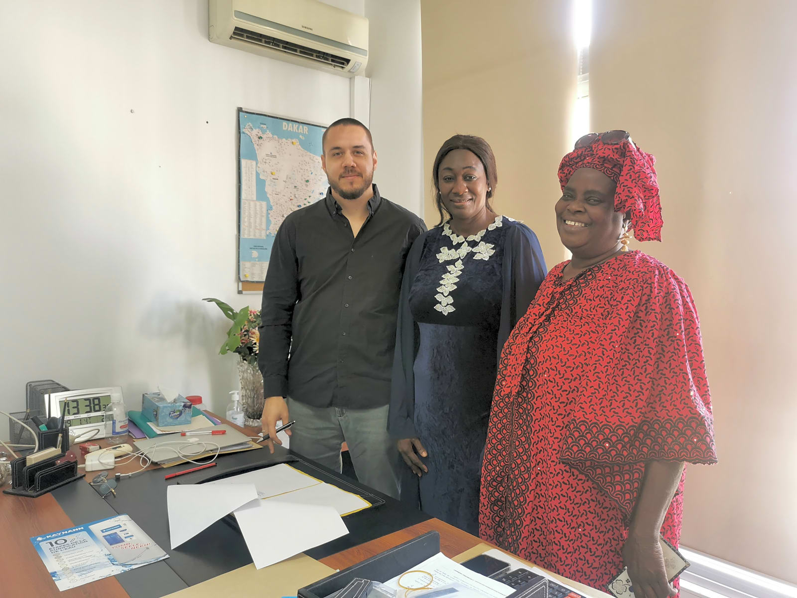  Три человека на деловой встрече в офисе в Сенегале, демонструющие сотрудничество в контексте маркетинга и бизнеса.