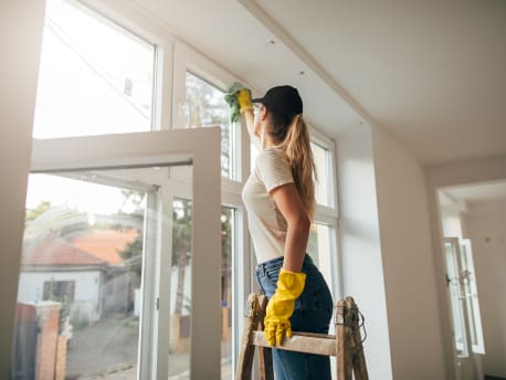 Frau beim Fenster putzen