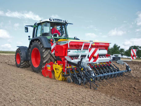 Traktor zieht PÖTTINGER Maschine