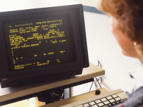 BayWa employee in front of a PC in the 1970s