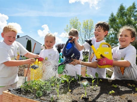 Children water the school garden of the BayWa Foundation