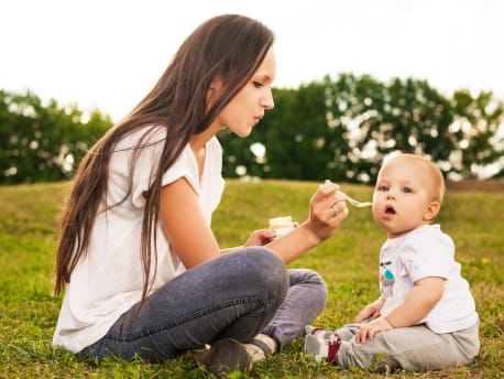 Mutter füttert Baby mit Brei