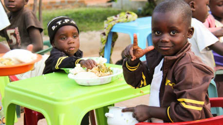 Kinder in Afrika an einem Tisch beim Essen