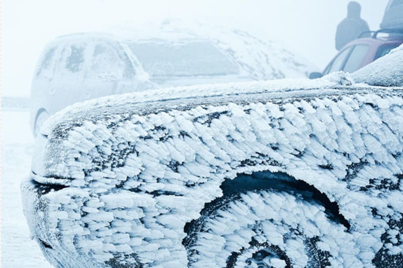 2 Autos mit Schnee bedeckt und vereister Scheibe