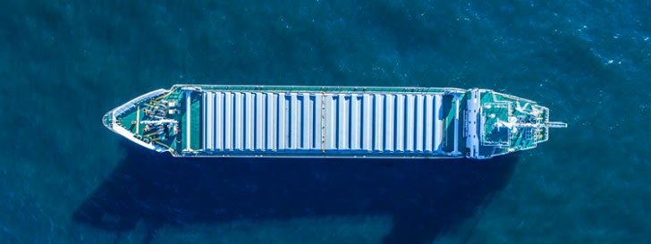 Picture shows a container ship in the ocean from an aerial perspective