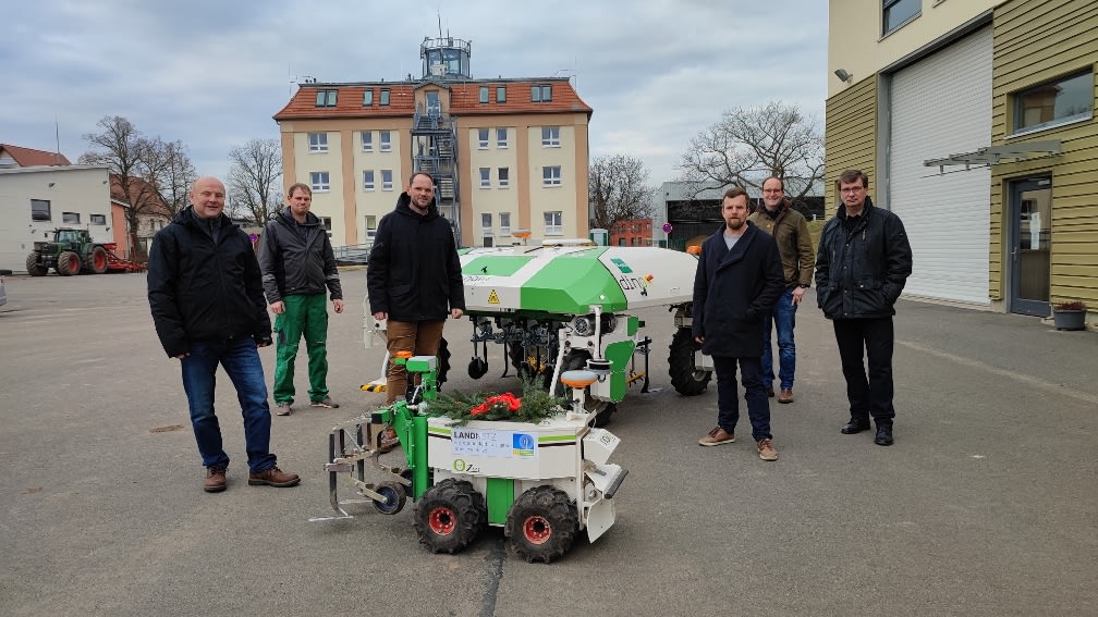 Menschen und die Agrarroboter "Dino" und "Oz"