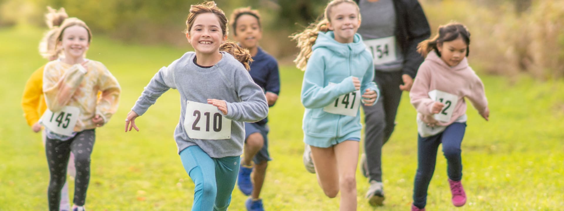 Kinder beim Spendenlauf im Endspurt über eine Wiese